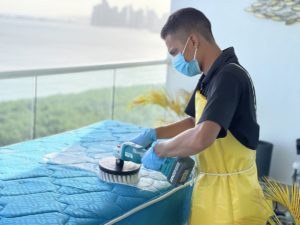 Técnico cepillando un colchón con cepillo rotativo